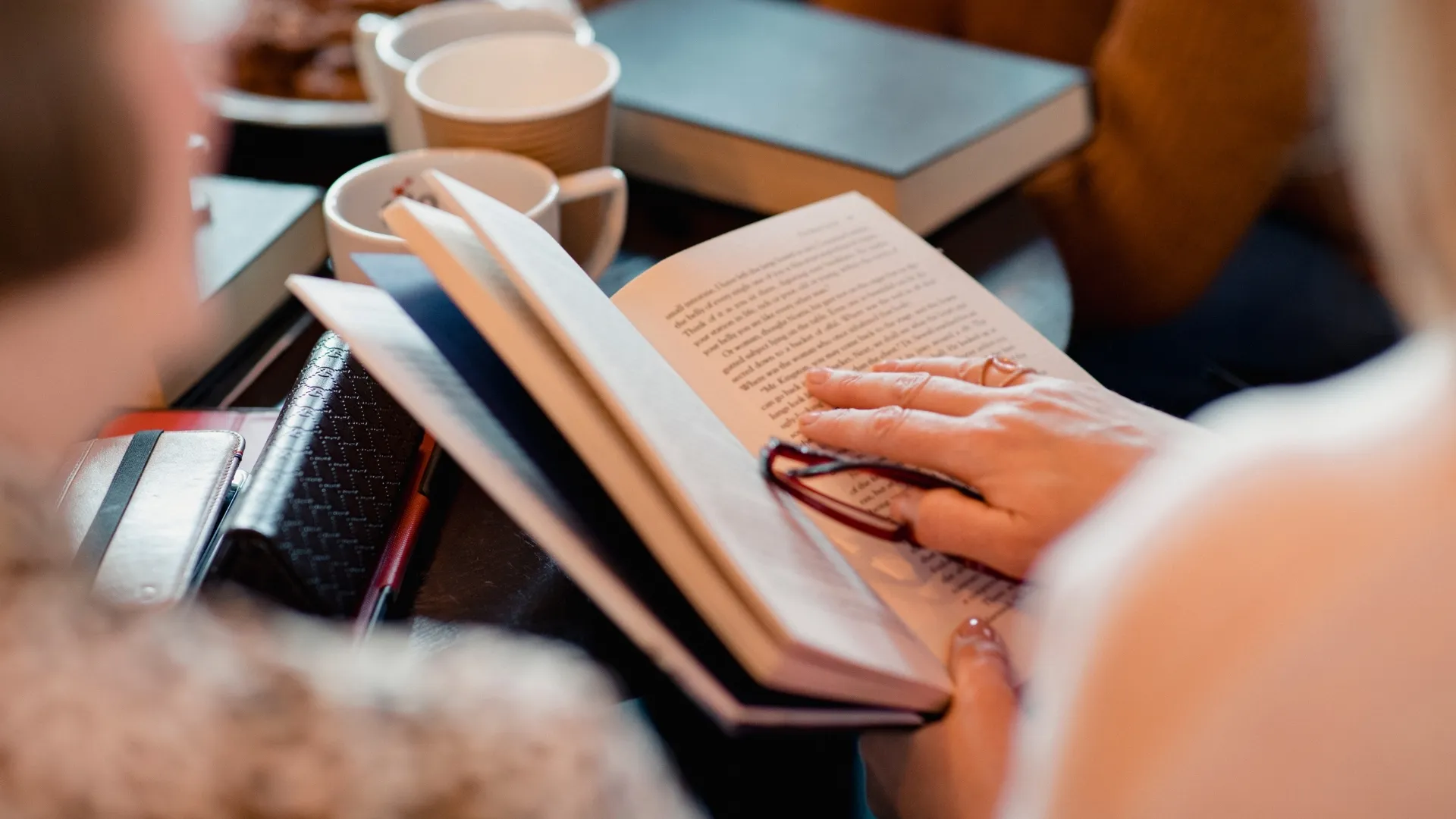 close up of a person's hand holding an open book