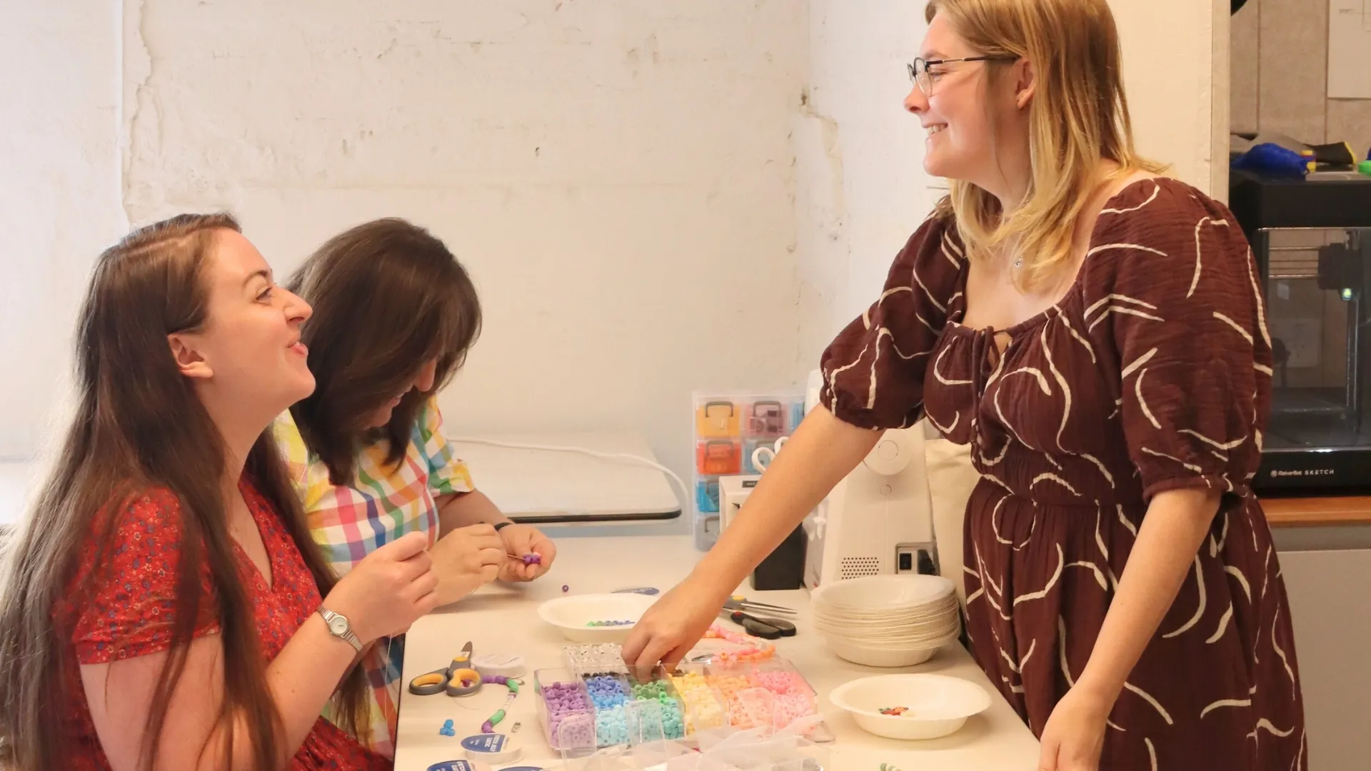 A group of three people doing bead crafts