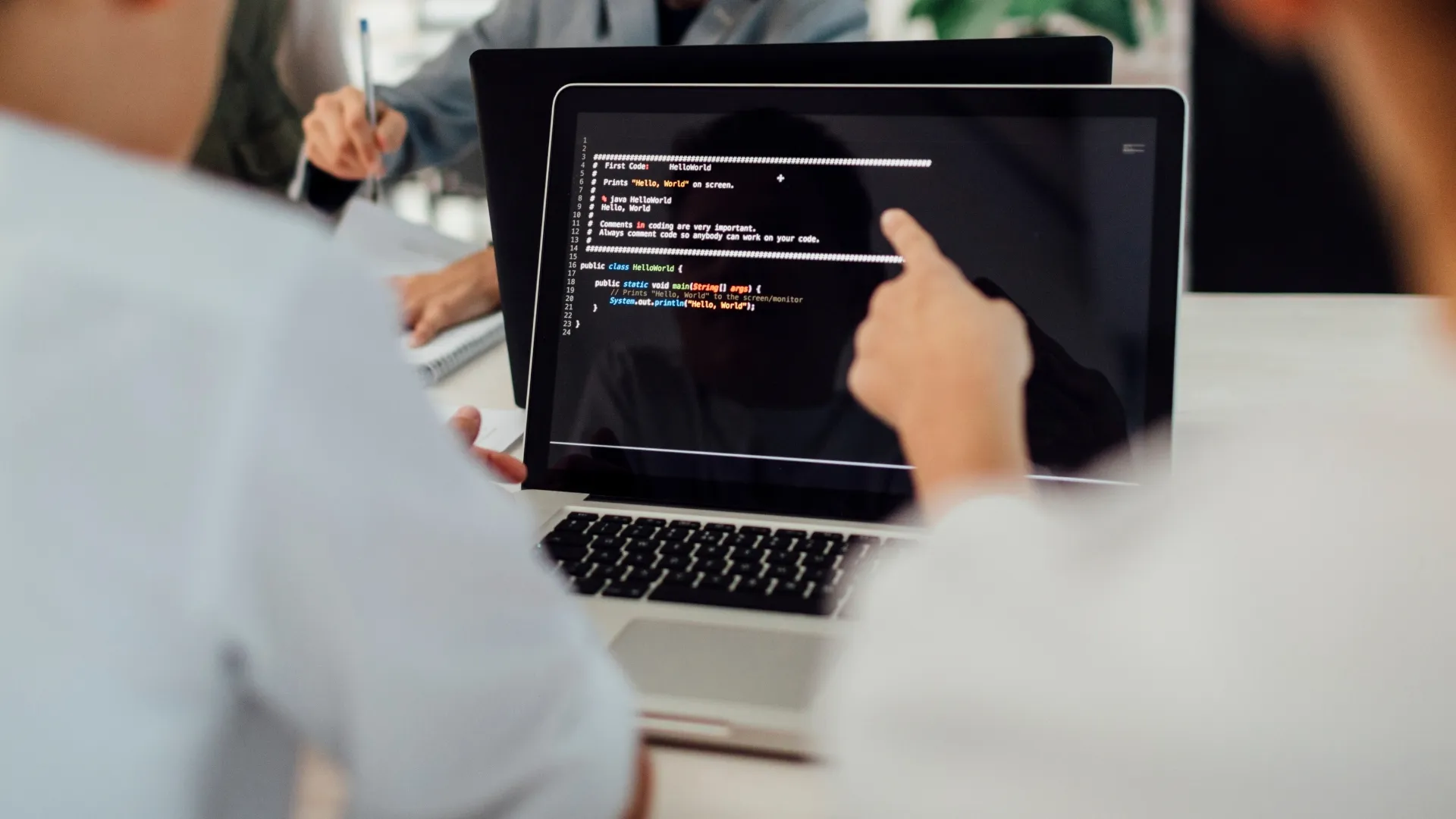 Close up of two people coding on a computer