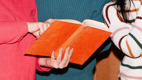 Close up of hands holding an open book 