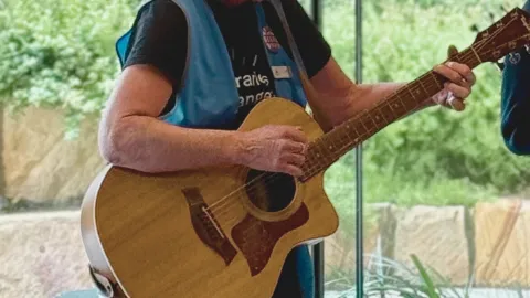close-up of person playing guitar