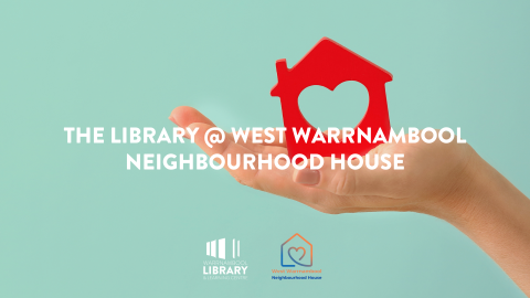 hand holding red house ornament on aqua background
